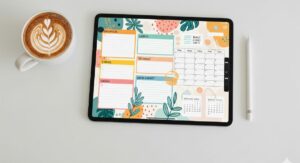 A flat lay of a tablet displaying a beautiful digital journal page, with a stylus and a cup of coffee nearby, showcasing the creative hobby of digital journaling.